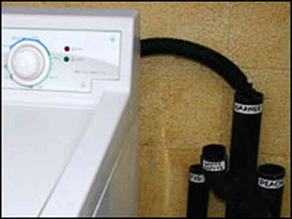 'Greywater' drains beside a washing machine.