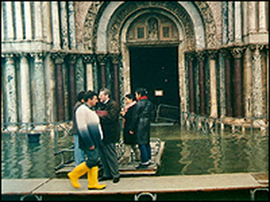 People walk on a raised walkway in St. Mark's Basilica in Venice.