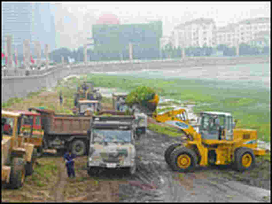 Diggers load up algae on trucks