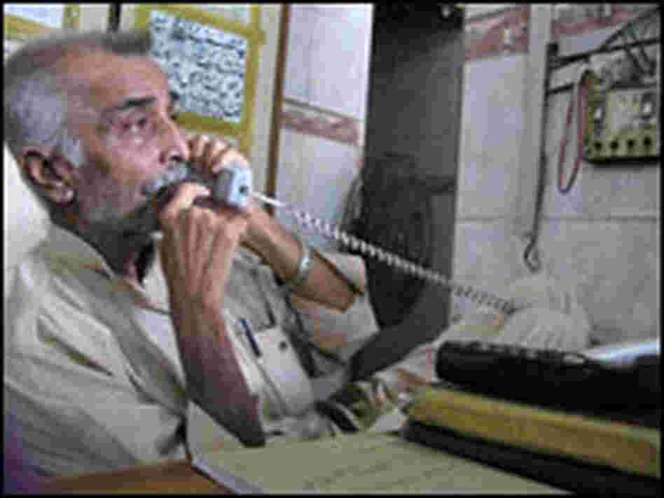 Anwar Kazmi talks on the phone at the Edhi Ambulance Service headquarters.