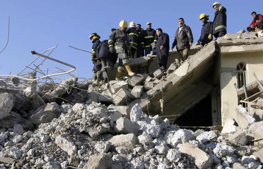 Iraqi firefighters search for wounded people amid rubble at the site of a deadly explosion in Mosul.