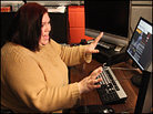 Stephanie Romanski gestures at a bank of computer monitors. Stephanie Romanski gestures at a bank of computer monitors.