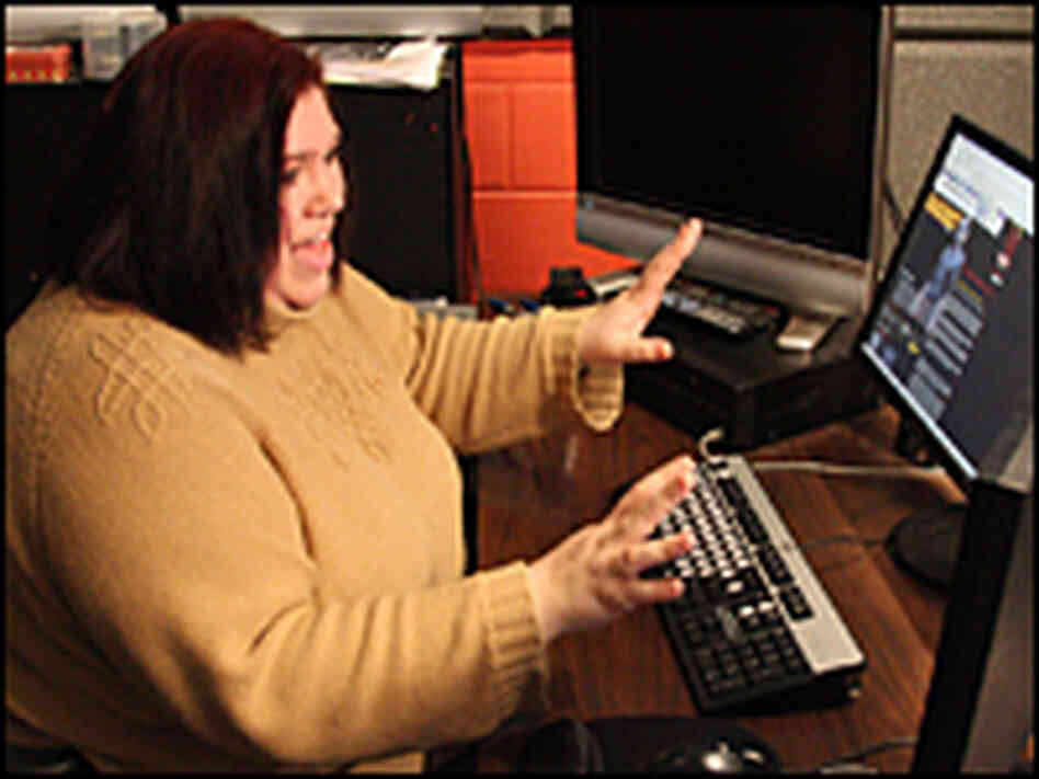 Stephanie Romanski gestures at a bank of computer monitors. Stephanie Romanski gestures at a bank of computer monitors.