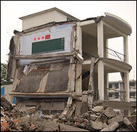 At the site of Juyuan Middle School, all that's left standing is the staircase. A blackboard still hangs on the wall of what used to be a third-floor classroom. Above the blackboard is a Chinese flag and a sign that reads
