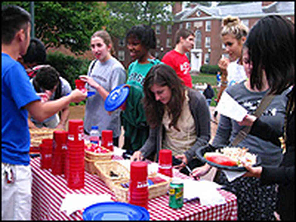 A group of UVA students serve themselves food from a table.