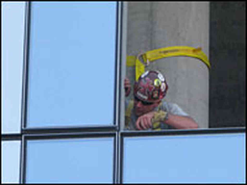An energy efficient glass panel being fitted into a downtown Portland building.