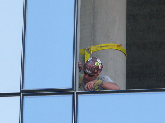 An energy efficient glass panel being fitted into a downtown Portland building.