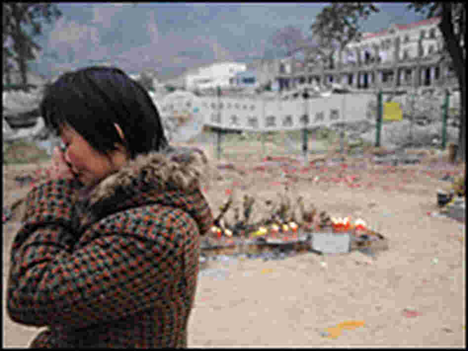 A woman mourns her dead child at the ruins of a middle school in China's Sichuan province