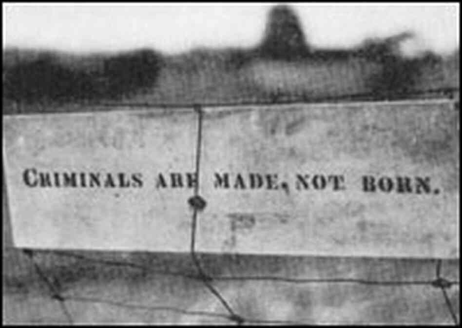 Sign on fence reads 'Criminals are made, not born.'