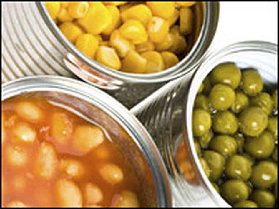 Three open canned food items. Three open canned food items.