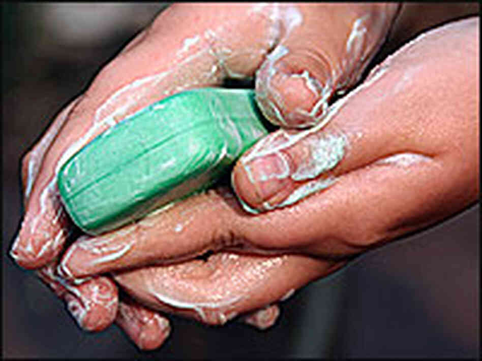 A person washes hands with soap. A person washes hands with soap.