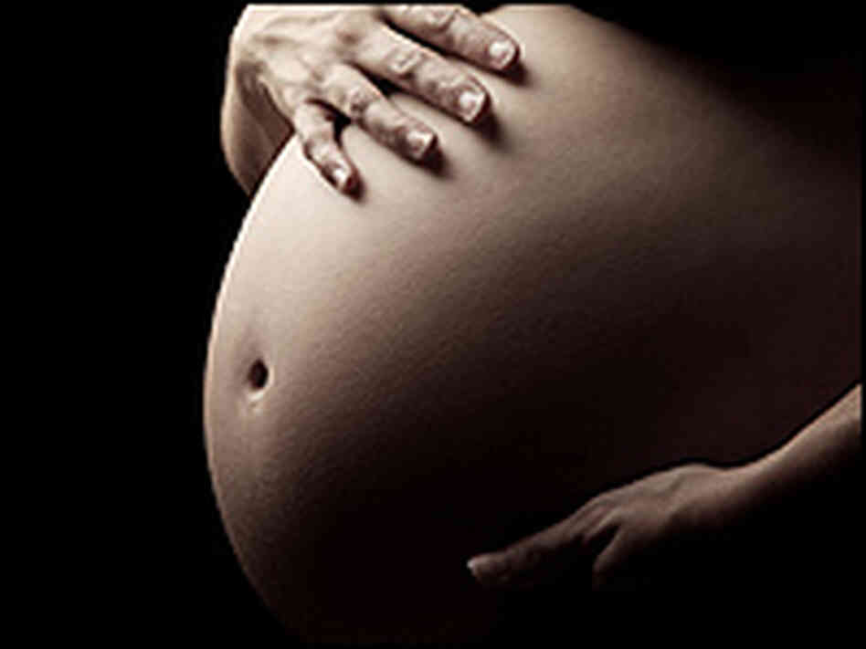 A close-up of a pregnant woman's stomach. A close-up of a pregnant woman's stomach.