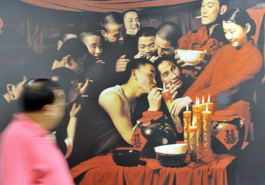 A man walks past a poster advertising Sotheby's auction of modern and contemporary Chinese art