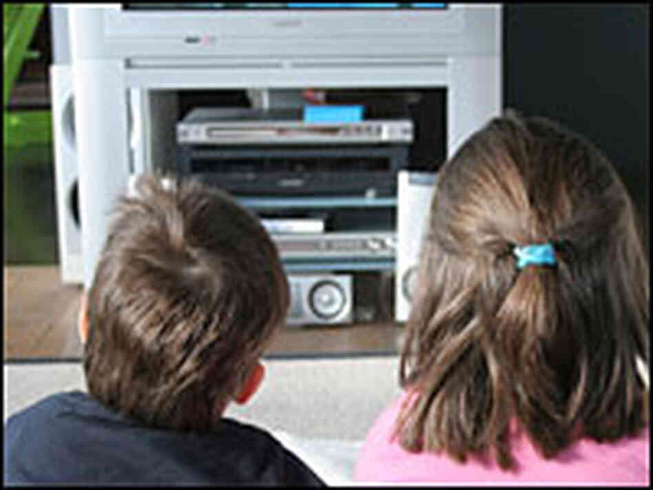 Two children watch television