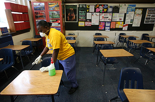 Fort Worth Independent school district custodian Necie Homer wipes down a classroom with disinfectan