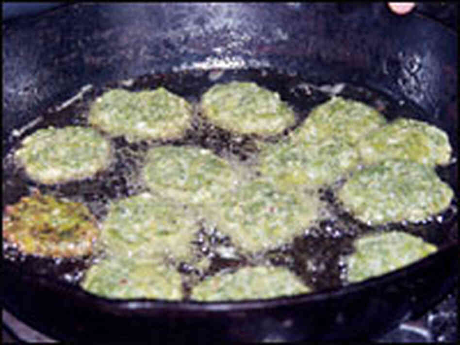 Fennel cakes fry in a cast-iron pan. Fennel cakes fry in a cast-iron pan.