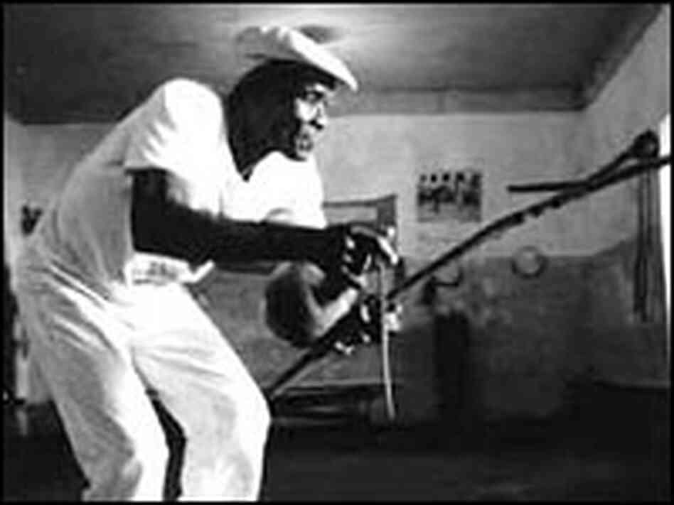Mestre Joao Grande plays the berimbau.