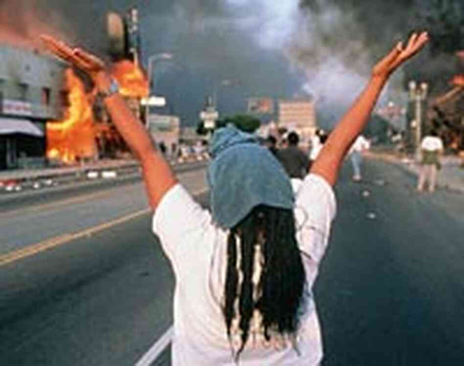 A woman watches as a business burns at the height of the 1992 riots in Los Angeles.