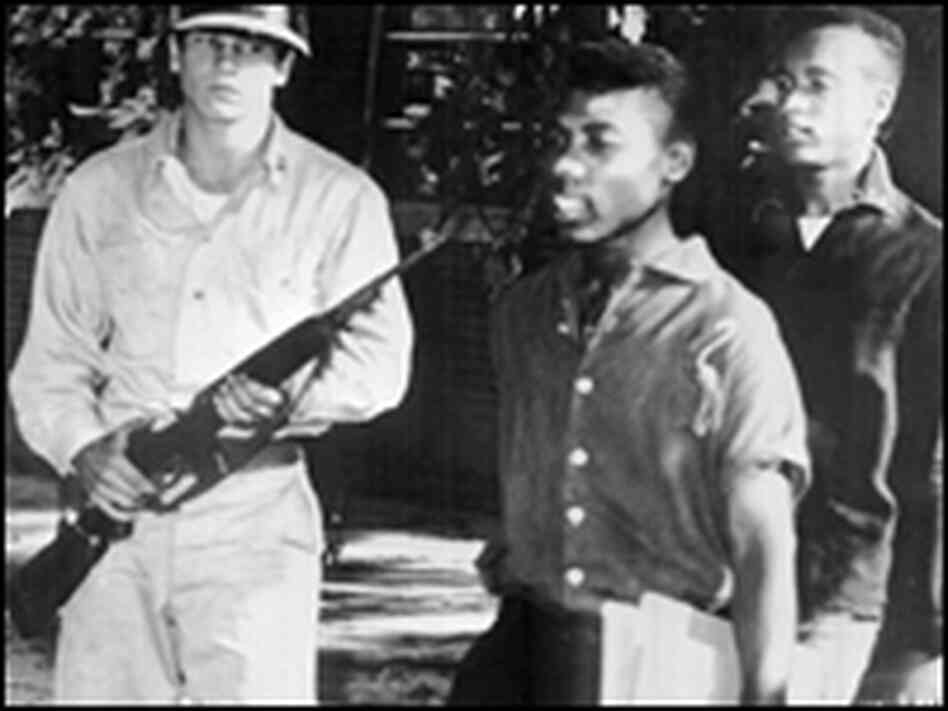 Paratroopers escort a black student from high school. Paratroopers escort a black student from high school.