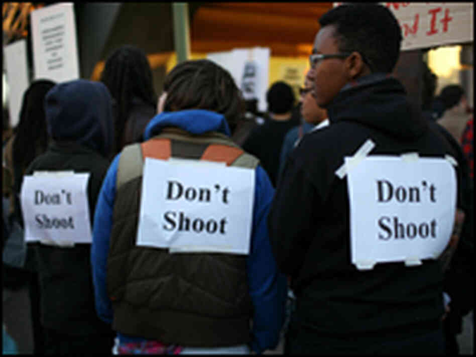 Protesters wear signs on their backs that say "don't shoot" Protesters wear signs on their backs that say "don't shoot"