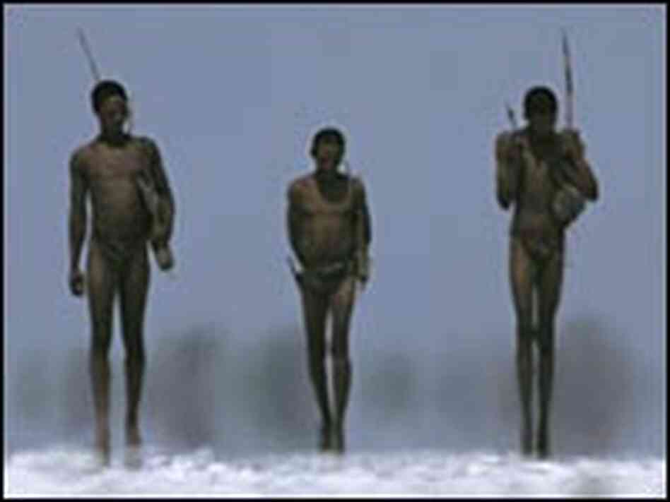 Bushmen armed with bows and arrows walk across a salt pan in Nyae Nyae Conservancy, Namibia.