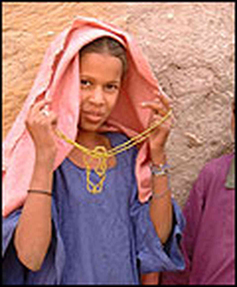 A girl living in the desert town of Araouane wearing a cloth head covering. A girl living in the desert town of Araouane wearing a cloth head covering.