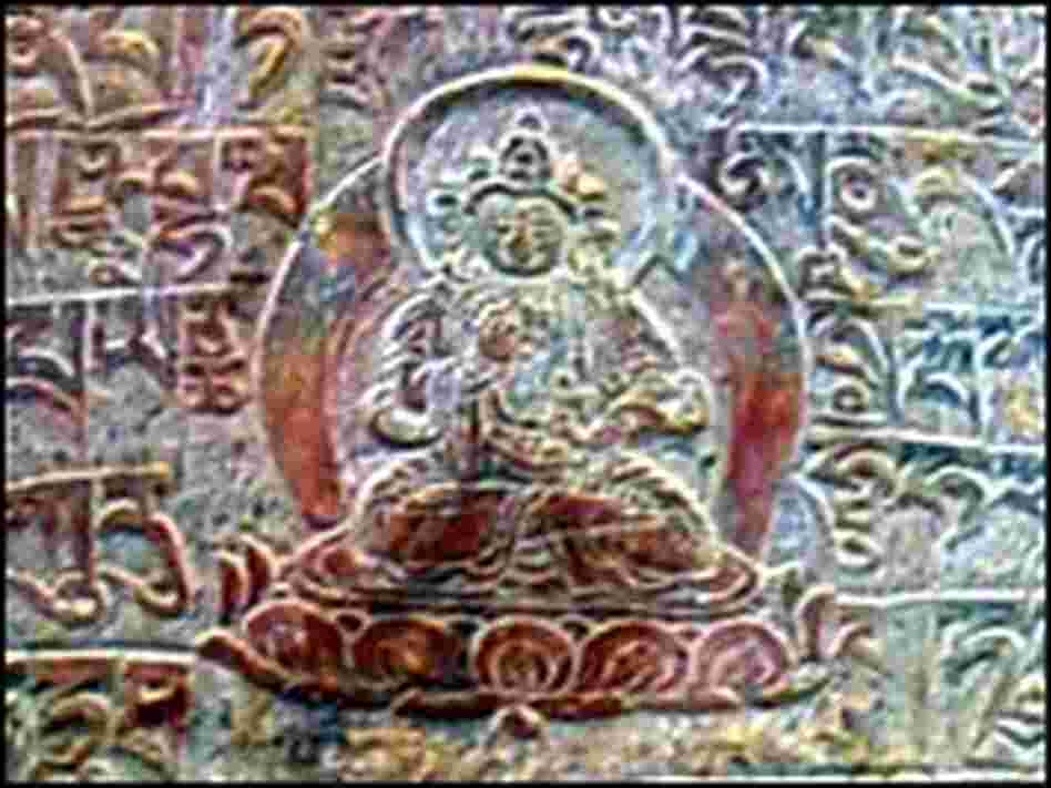 Image of Buddha with prayers in Tibetan script inscribed into the mountain rock
