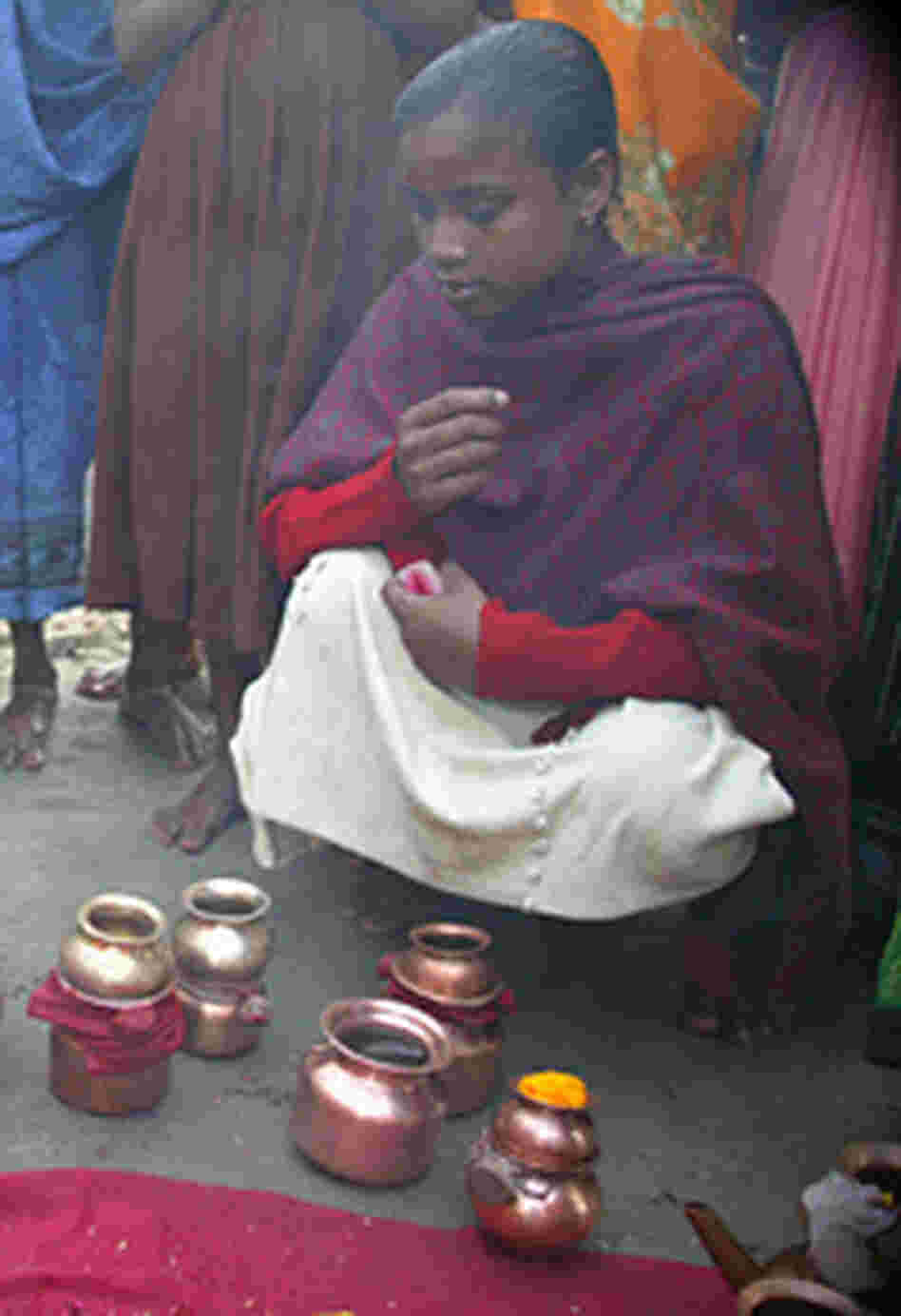 Young women tend a makeshift shrine on the shores of the Yamuna River