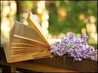 Open book alongside lilac