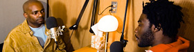 Oral History: Two men record their stories in a StoryCorps booth.
