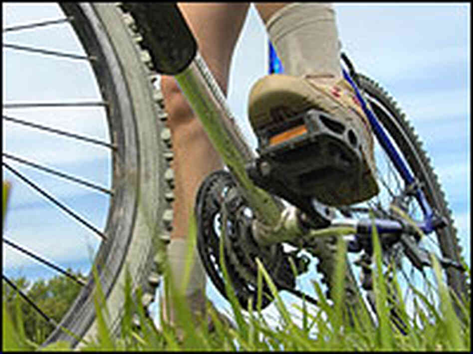 A foot on a bike pedal. A foot on a bike pedal.