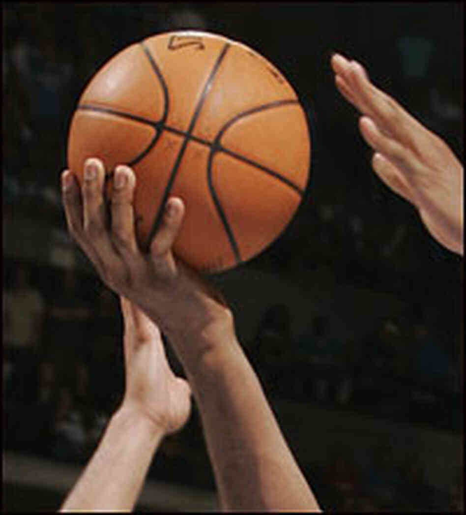 Hands of players grasping for basketball. Hands of players grasping for basketball.