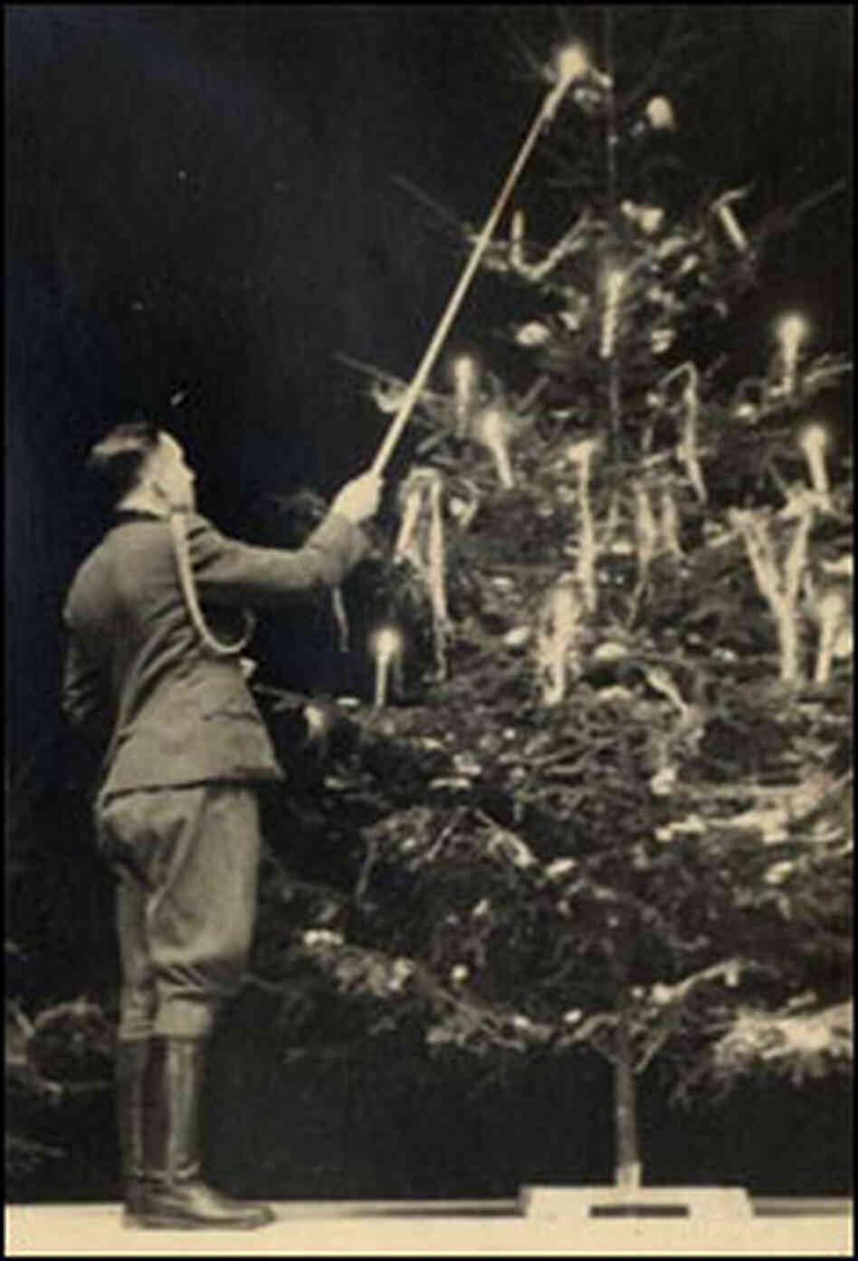 SS officer Karl Hocker lights a candle on a Christmas tree. SS officer Karl Hocker lights a candle on a Christmas tree.