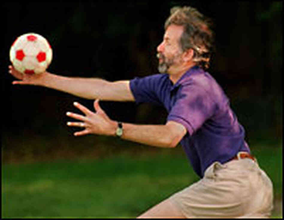 Michael May reaches to catch a soccer ball.
