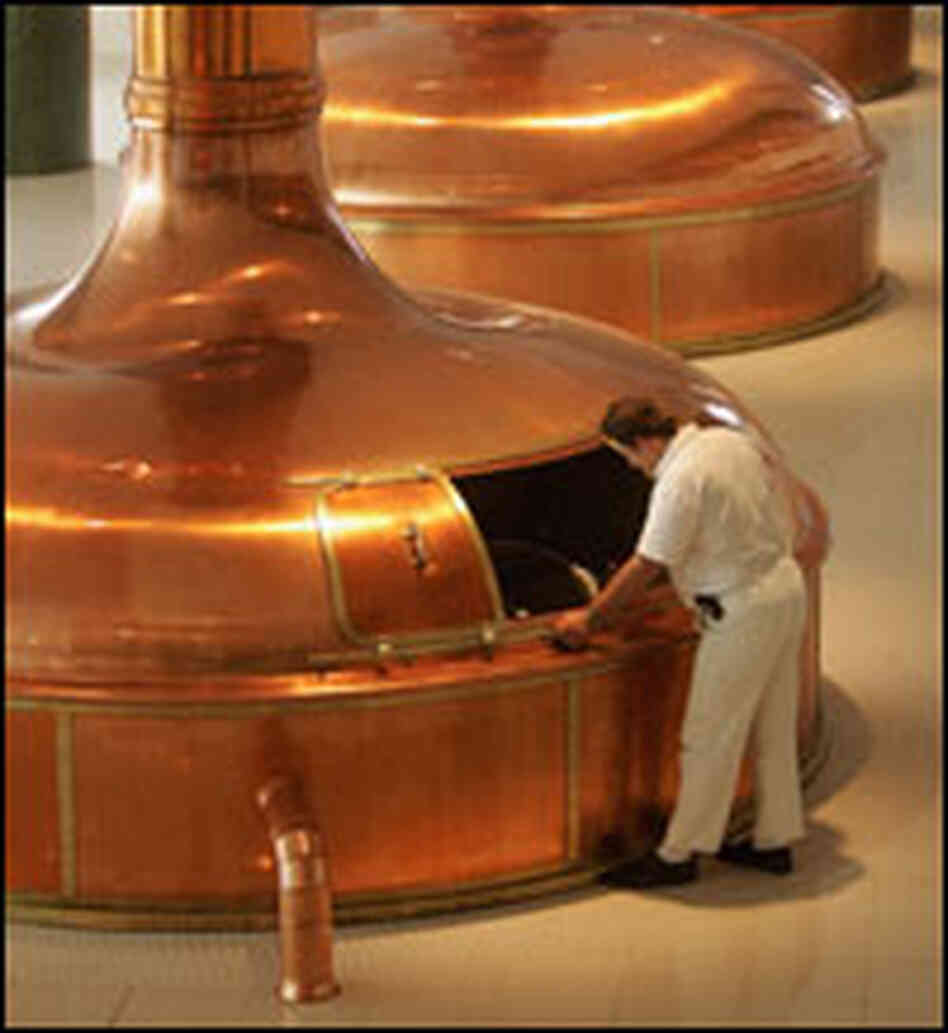 A worker checks the brew in giant copper vats at the Prazdroj brewery in Pilsen, Czech Republic.