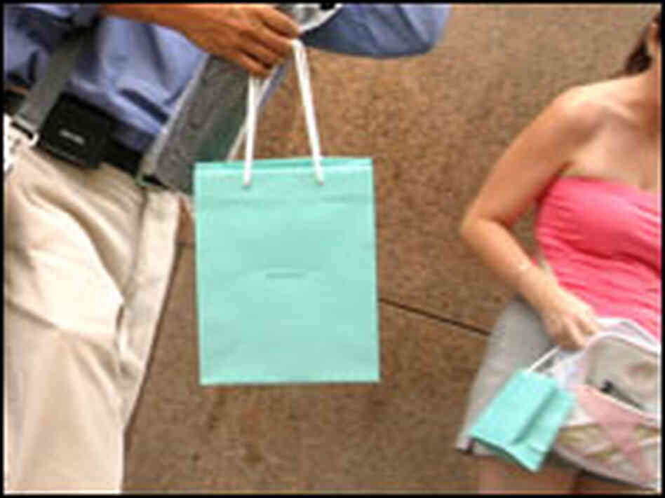 Shoppers walk with Tiffany's bags. Shoppers walk with Tiffany's bags.
