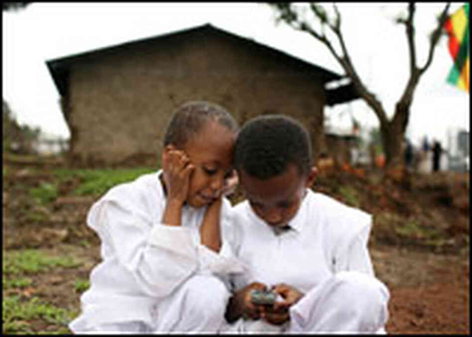 Ethiopian children play with a cell phone