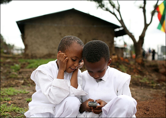 Ethiopian children play with a cell phone