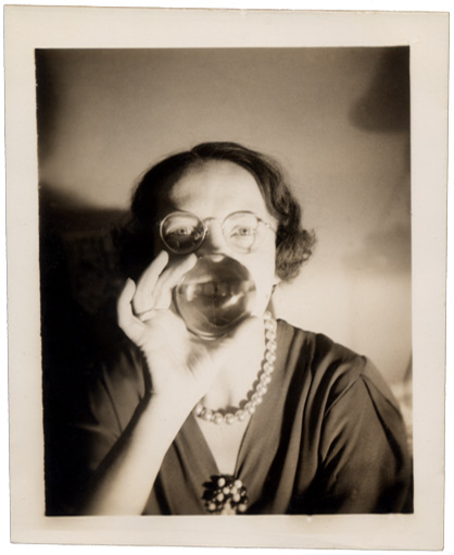 A woman smiling through a glass ball.