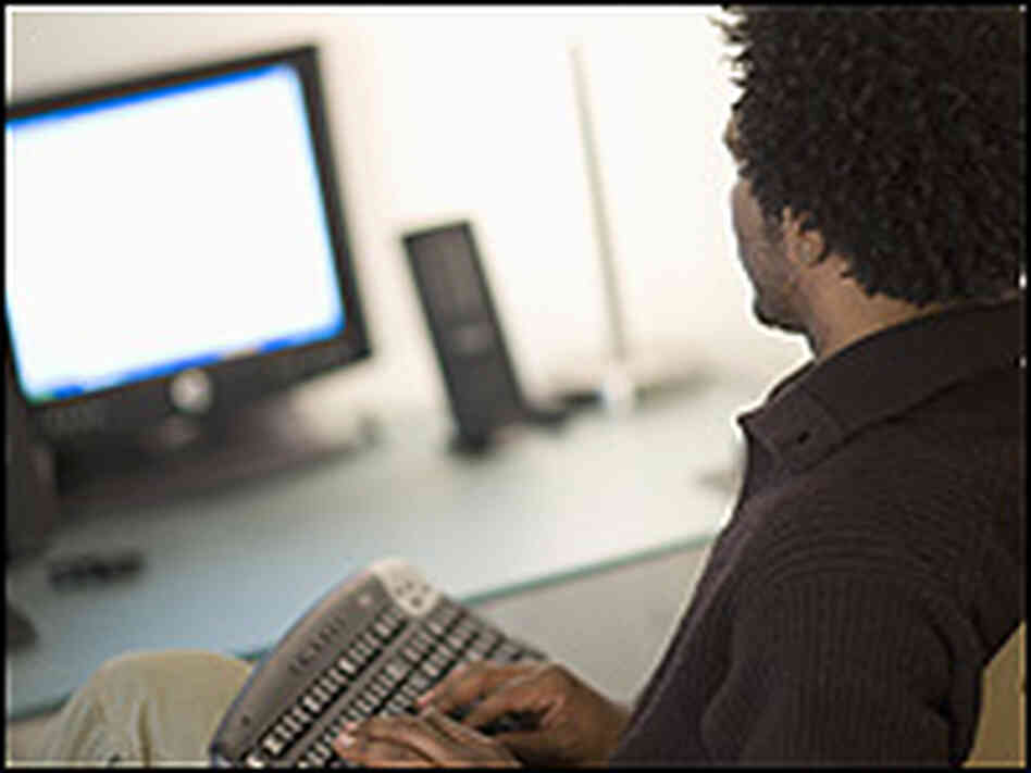 A man types at a computer. A man types at a computer.