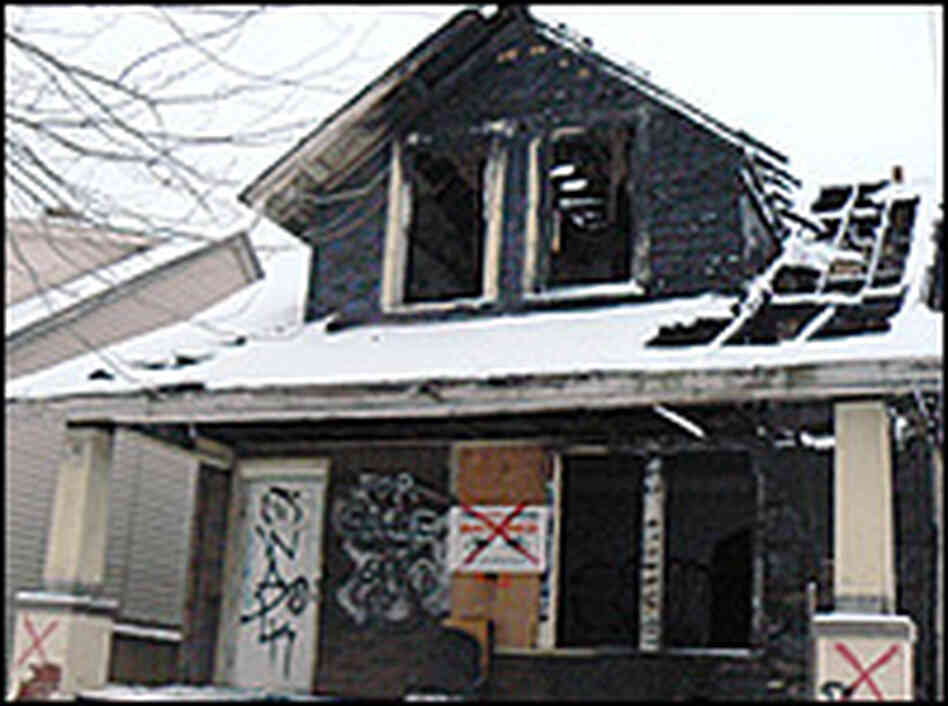 A burned-out home bears red X's.