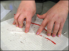 Rolling licorice strands in silver foil. Travis Larchuk/NPR Rolling licorice strands in silver foil. Travis Larchuk/NPR