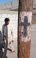 Activists paint a cross on streetlight poles.
