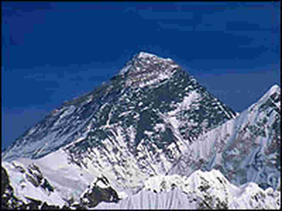 Mount Everest's snowy summit against a bright blue sky.