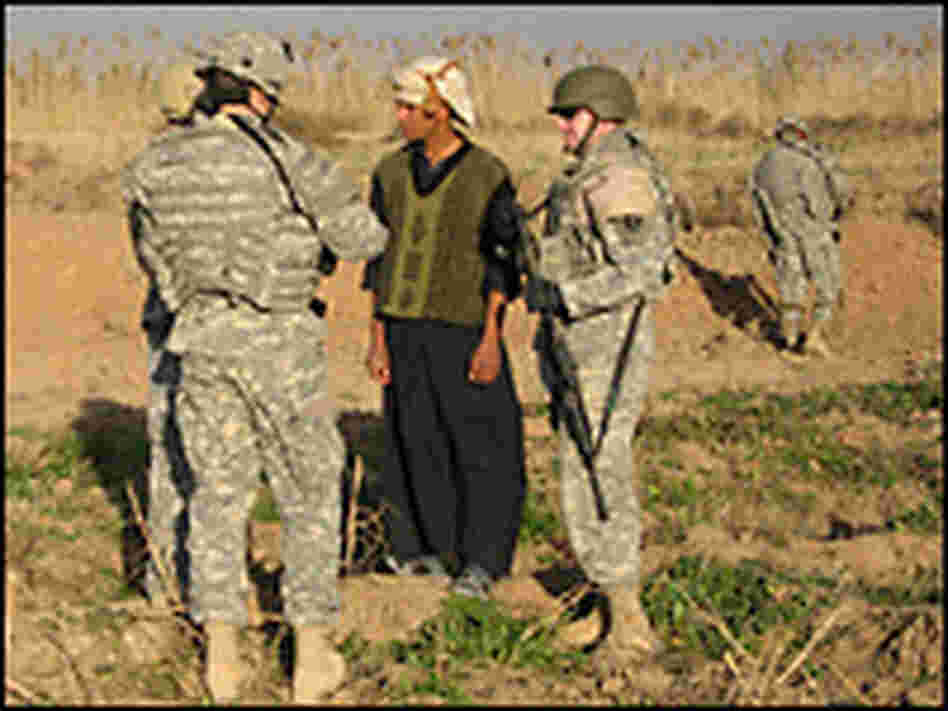 U.S. soldiers question an Iraqi farmer. Credit: John McChesney, NPR.