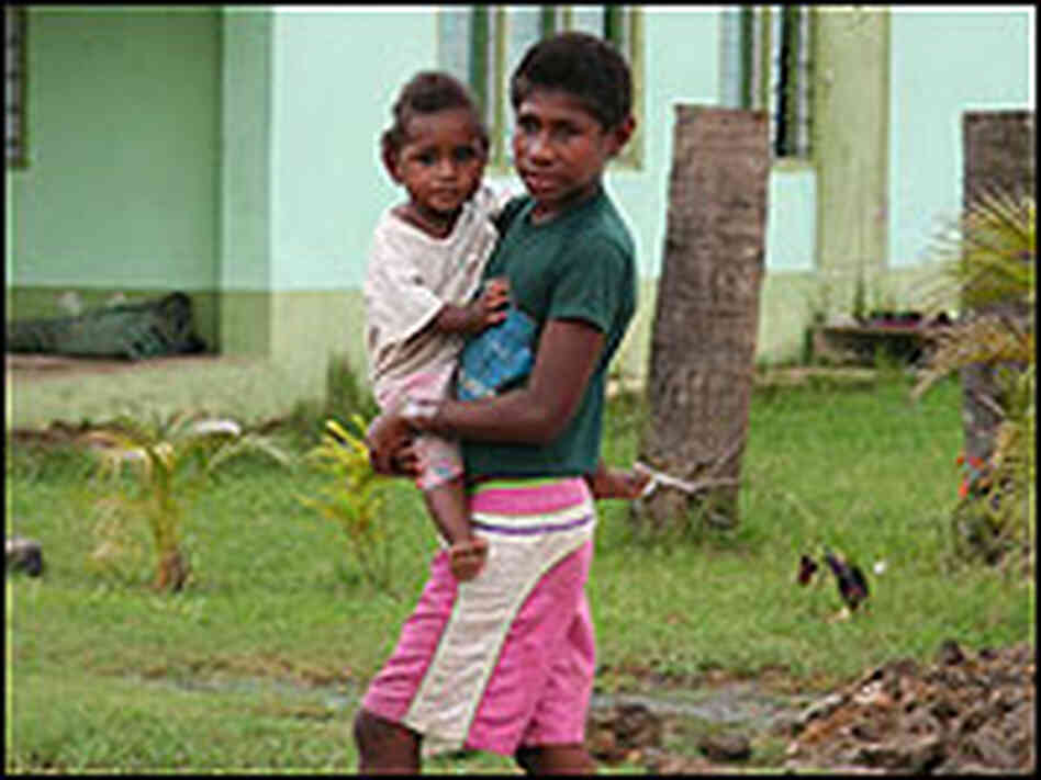 A boy carries a small child on the island of Viti Levu. A boy carries a small child on the island of Viti Levu.
