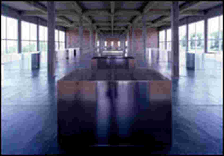 Glass walls let the sunlight play against the surfaces of 100 boxes in old artillery sheds.