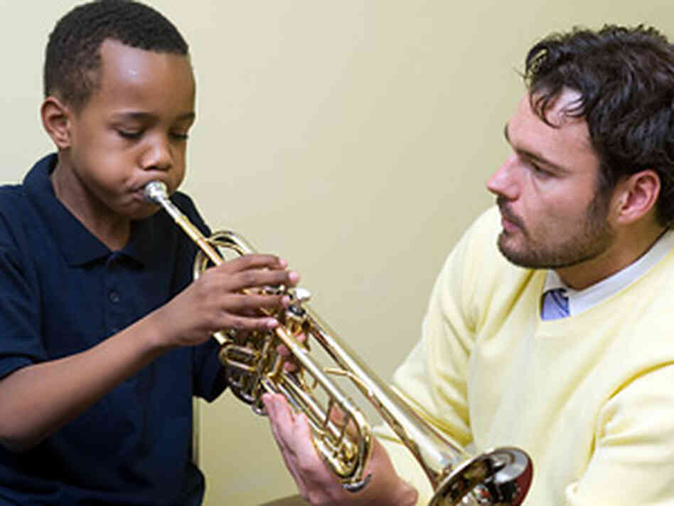 Dan Trahey, director of the Baltimore Symphony's Orchkids program, helps a student Dan Trahey, director of the Baltimore Symphony's Orchkids program, helps a student