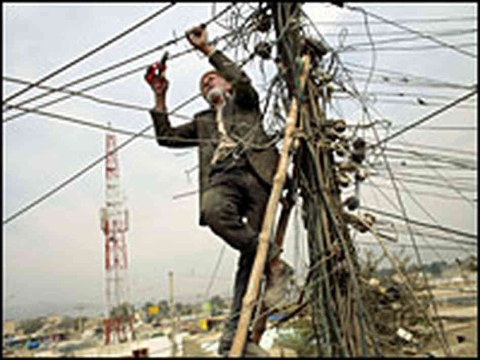 A power plant worker cuts old power lines in Kabul