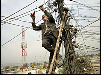 A power plant worker cuts old power lines to improve the electricity in a residential neighborhood in Kabul in November 2006.
